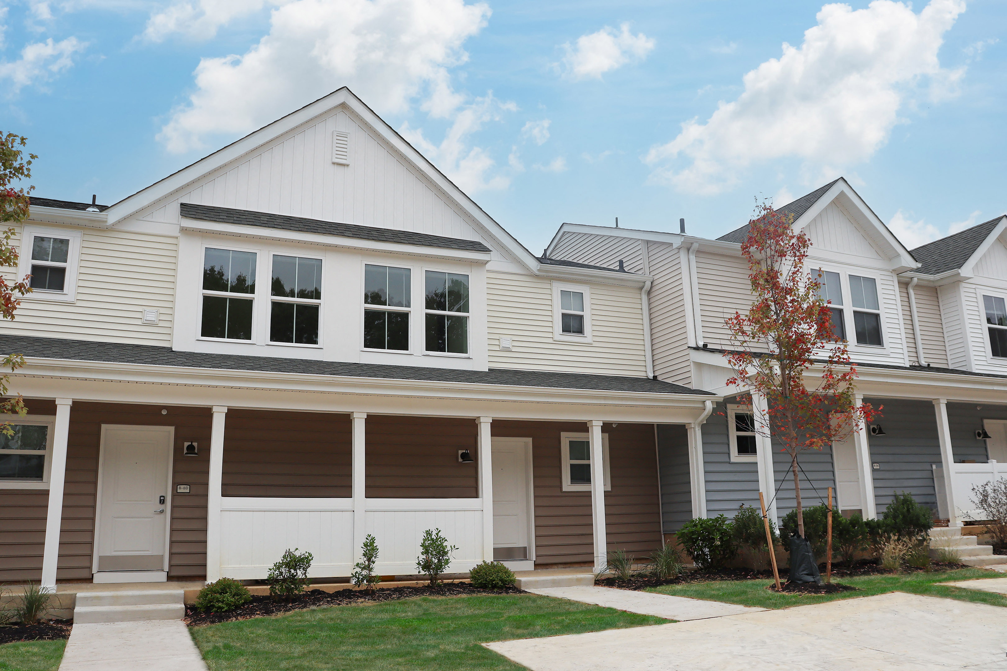 the exterior of a white house with brown and white siding